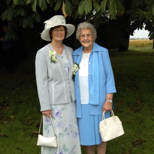 Helen's mum and nan at her wedding, sharing a joyful moment together. A special family memory capturing love, tradition, & generations of creativity.